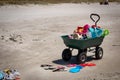 Beach buggy wheelbarrow, sandals, and sand sculpture tools, Matarangi Beach, New Zealand Royalty Free Stock Photo