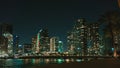 the beach and buildings of downtown at night time, and with the sea as background