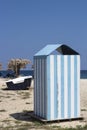 Beach cabin with blue and white strips on sand in Greece. Retro Royalty Free Stock Photo