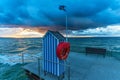 Beach cabin with a life buoy by the sea at sunset Royalty Free Stock Photo