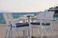 Beach cafe with sea view at sunset, empty table, four chairs, vacant for guests. Royalty Free Stock Photo