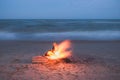 Beach campfire on sand shore. Burning wood on white sand i Royalty Free Stock Photo