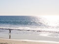 Beach in Carlsbad, California, United States of America. Near San Diego. A kid dancing on a beautiful beach with sunshine.