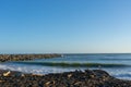 Beach at Castlecliff with. rock groyne breakwater projecting into sea with fishers