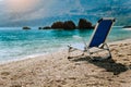 Beach chair from back on tranquil pebble beach. Amazing view to impressive rocks in the water. Serenity and isolation on Royalty Free Stock Photo