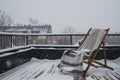 beach chair with a cozy blanket on a snowy rooftop deck Royalty Free Stock Photo