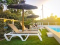 Beach chair in front of clear blue water of swimming pool