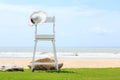Beach chair on green grass, white sand and sea on blue sky background Royalty Free Stock Photo