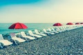 Beach chairs or beds and sun red umbrellas on the beach Royalty Free Stock Photo