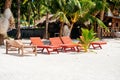 Beach chairs, palm trees and beautiful white sand beach in tropical island