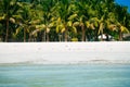 Beach chairs, palm trees and beautiful white sand beach in tropical island Royalty Free Stock Photo