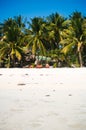 Beach chairs, palm trees and beautiful white sand beach in tropical island Royalty Free Stock Photo