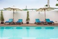 Beach chairs and swimming pool in the resort holiday. Royalty Free Stock Photo