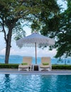 beach chairs at a swimming pool with umbrellas Royalty Free Stock Photo