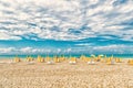 Beach chairs and umbrellas on cloudy sky in miami, usa. Sea beach with white sand and blue water on sunny day. Summer Royalty Free Stock Photo