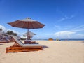 beach chairs with umbrellas during the day with the backdrop of a beautiful bali beach on white sand