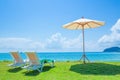 Beach chairs and beach umbrellas are on the lawn at the beach.Sea view and bright sky. Royalty Free Stock Photo