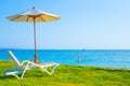 Beach chairs and beach umbrellas are on the lawn at the beach.Sea view and bright sky