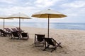 Beach chairs under a cream umbrella on the fine beach. Royalty Free Stock Photo