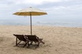 Beach chairs under a cream umbrella on the fine beach. Royalty Free Stock Photo