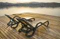 Beach chairs on a wooden platform by the sea before sunset. Royalty Free Stock Photo