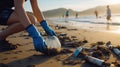 Beach cleaning, Volunteer collects plastic garbage in a bag on the seashore, Clean up trash, Save earth concept