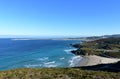 Beach with cliff and port. Blue sea with waves and white foam. Sunny day, Arteijo, Coruna, Spain. Royalty Free Stock Photo