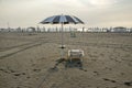 Beach with closed umbrellas, ready one sun lounger and opened umbrella, romantic scene, early morning in Sottomarina, Italy Royalty Free Stock Photo