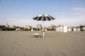 Beach with closed umbrellas, ready one sun lounger and opened umbrella, romantic scene, early morning in Sottomarina, Italy Royalty Free Stock Photo