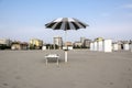 Beach with closed umbrellas, ready one sun lounger and opened umbrella, romantic scene, early morning in Sottomarina, Italy Royalty Free Stock Photo