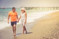 Beach couple walking on romantic travel honeymoon vacation summer holidays romance. Young happy lovers, Caucasian woman and man ho Royalty Free Stock Photo