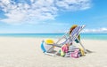 Beach deck chair for sunbathing on a sunny day by the seaside, beach ball and a bag full of accessories, concept of a summer beach Royalty Free Stock Photo