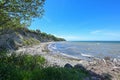 Beach with driftwood, stones and sand in front of the steep coast at the Baltic Sea, beautiful landscape for leisure activities,