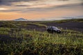 Beach dunes in Iceland with a SUV and volcanos in the background during the midnight sun..15/06/2019 - Hella, Iceland