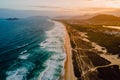 Beach with dunes, ocean and town with warm sunset in Campeche, Florianopolis