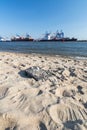 Beach at the Elbe river in Hamburg with container terminal and ships in the background Royalty Free Stock Photo
