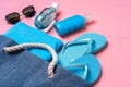 Beach essentials and blue beach bag on pink background