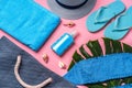 Beach essentials and blue beach bag on pink background