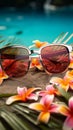 Beach essentials Sunglasses, colorful flowers, and tropical palm leaves for a perfect summer