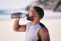 Beach, exercise and man drinking water after running, workout or cardio fitness for health. Hydration, drink and thirsty Royalty Free Stock Photo