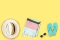 Beach female accessories, straw beach hat, towel, sunglasses on yellow. Space for text. Summer tropical vacation Royalty Free Stock Photo
