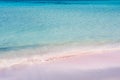 The beach with fine pink sand, bathed by the clear waves of the