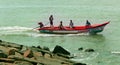 Beach with fishermen wooden motor boat.