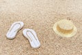 Beach flip-flops and hat on sandy beach. Beach accessories Royalty Free Stock Photo