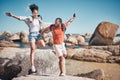 Beach, freedom and happy couple jumping on rocks together while on seaside summer vacation. Happiness, travel and young Royalty Free Stock Photo