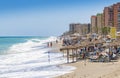 Beach-front with people bathing in waves Fuengirola Spain