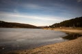 Beach by the frozen lake. Beautiful sunny winter day. Royalty Free Stock Photo