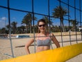 Beach girl smiling behind the volleyball net Royalty Free Stock Photo