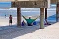 Beach goers hangout underneath a concrete pier at St. Augustine Beach, Florida usa