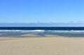 Beach with golden sand and blue sea with waves and foam. Clear sky, sunny day. Galicia, Spain. Royalty Free Stock Photo